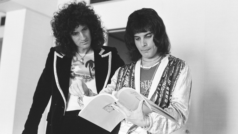 candid photo of freddie mercury and brian may