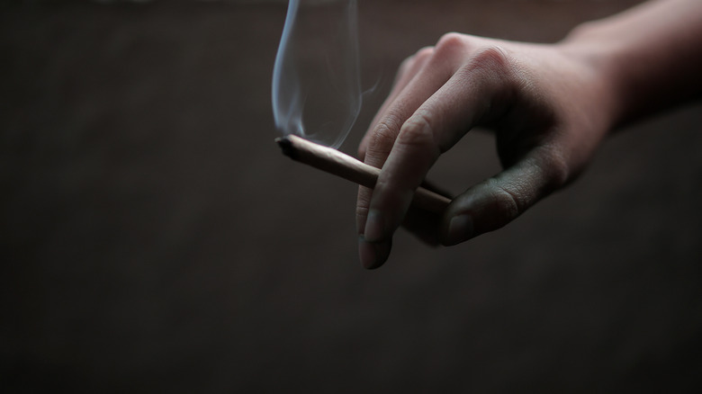 a marijuana cigarette in someone's hand