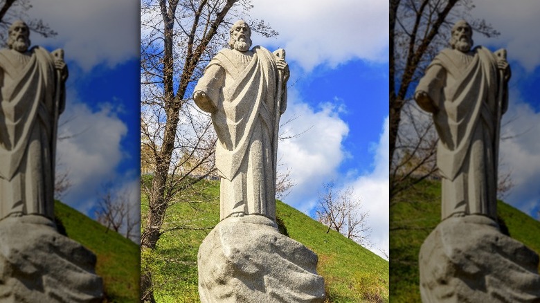 Statue of St. Andrew before hill, blue sky