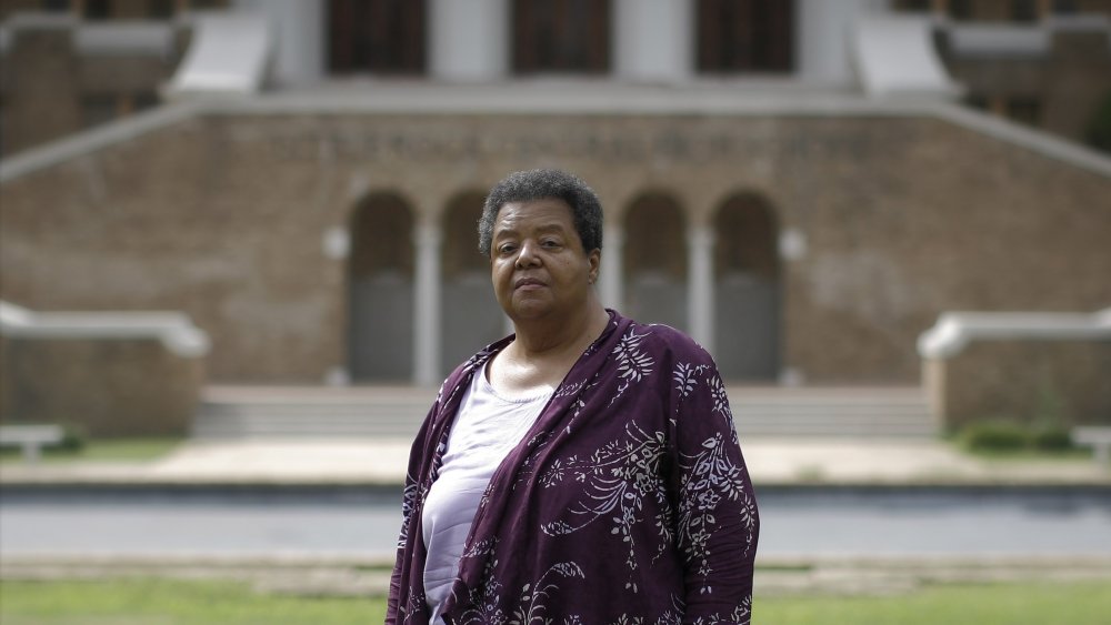 Elizabeth Eckford poses in front of Central High as an adult