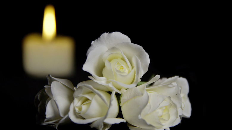 Candle and white roses