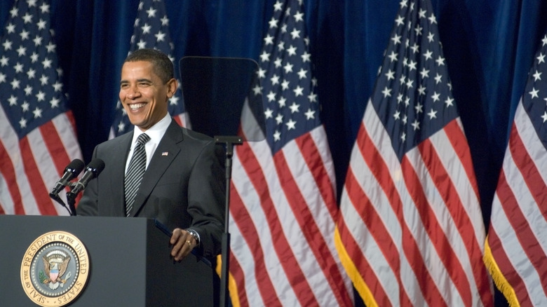 Barack Obama speaking American flags