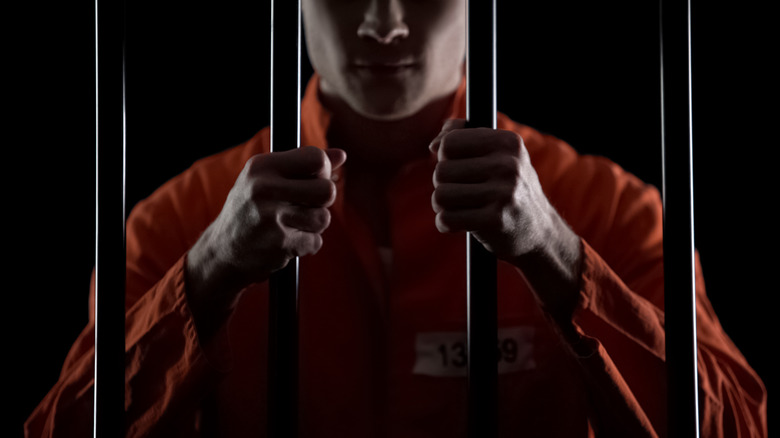 inmate holding prison bars
