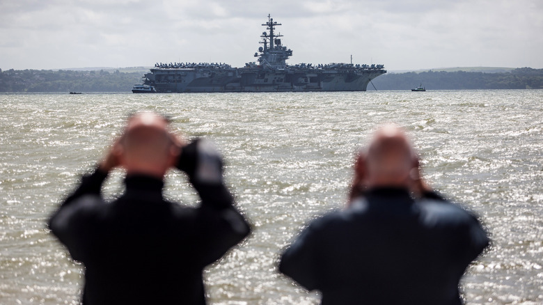 Sailors looking at ship with binoculars 