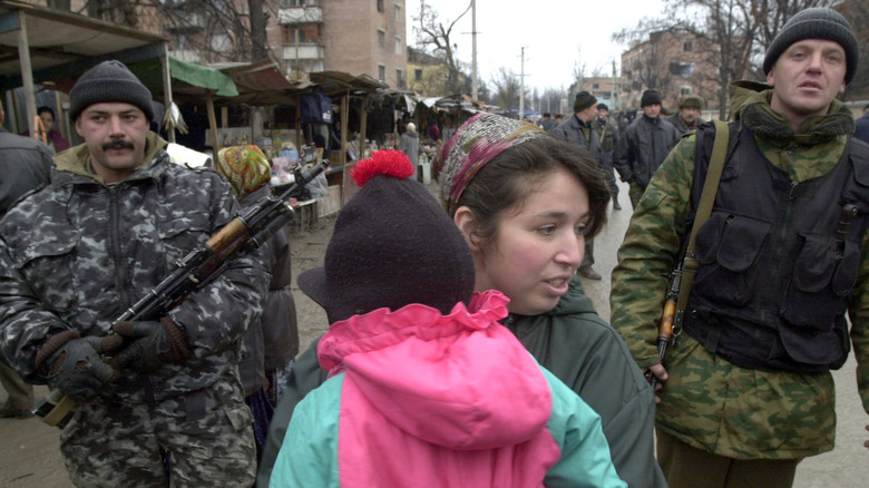Russian soldiers escort Chechen civilians