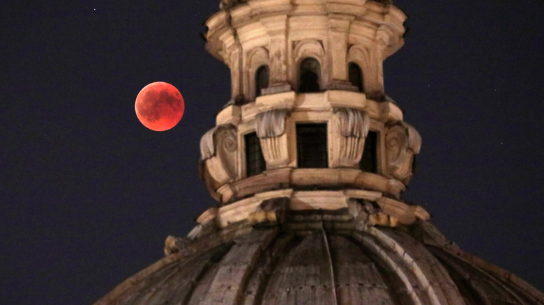 Blood moon eclipse over a building