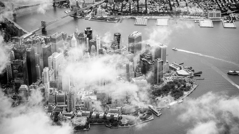 black and white aerial view of manhattan through clouds