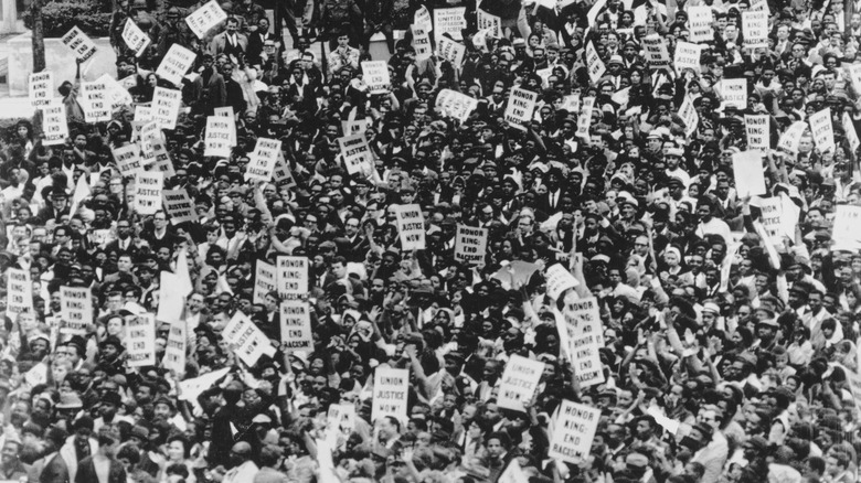 Crowd marching holding signs
