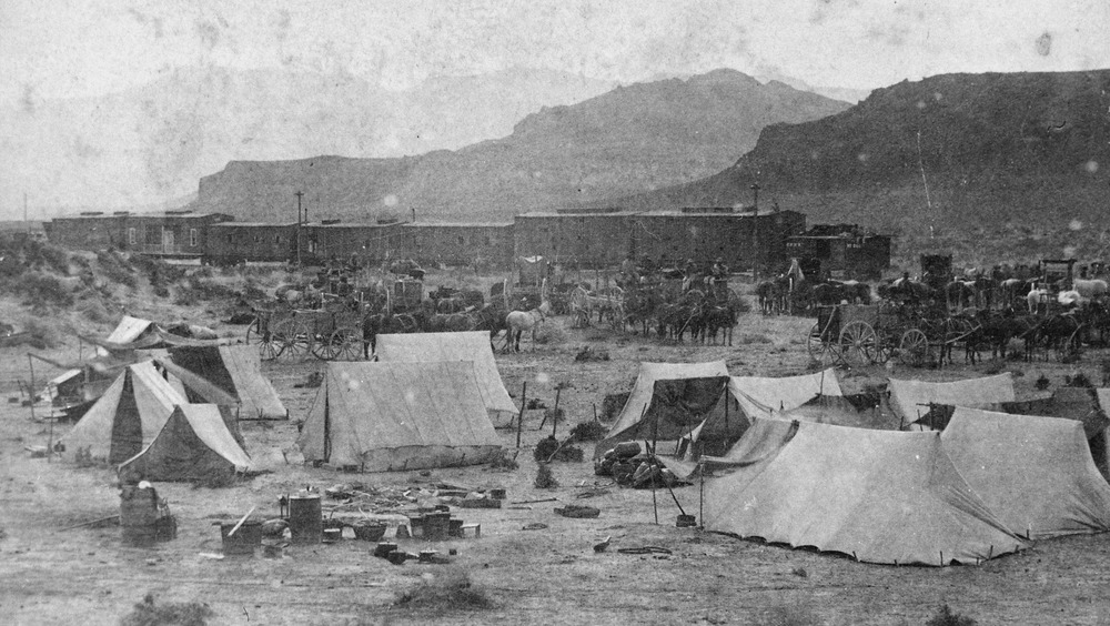 "End of the Track. Near Humboldt River Canyon, Nevada." Campsite and train of the Central Pacific Railroad at foot of mountains, 1868