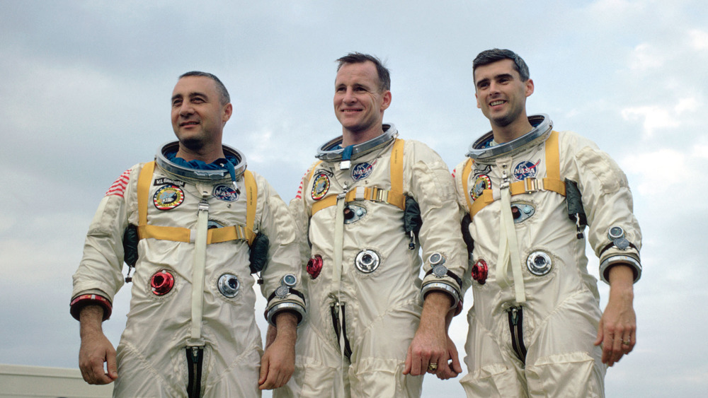 Gus Grissom, Ed White and Roger Chafee standing and smiling 