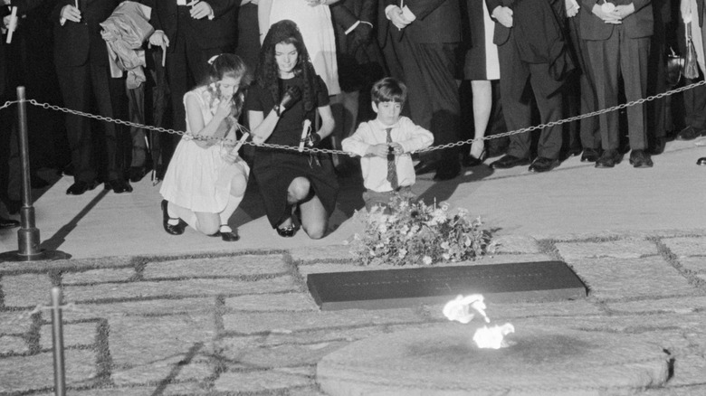 Jackie Kennedy kneeling at the eternal flame