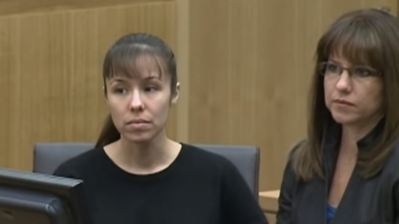 Jodi Arias listening beside lawyer dark shirt
