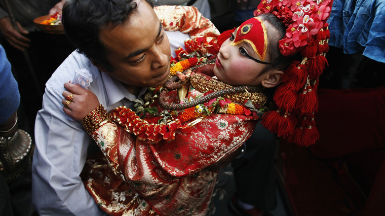 Preeti Shakya, 8, is carried carefully into her chariot before being carried through the streets of the city during the Ghode Jatra festival March 18, 2007 in Kathmandu, Nepal