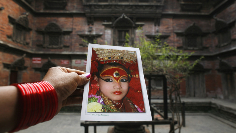 Preeti Shakya, 8, is seen on a postcard for sale in front of the Kumari Ghar, the home of the Living Goddess built in 1757 March 27, 2007 in Kathmandu, Nepa