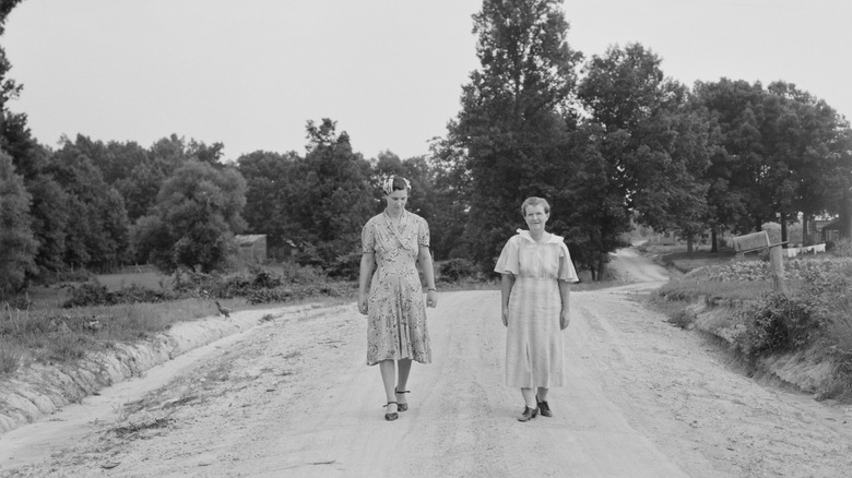 Two women walking on dirt road