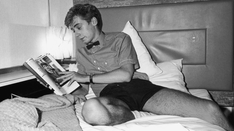 Singer and guitarist Nick Heyward reads in a hotel in 1982, black and white