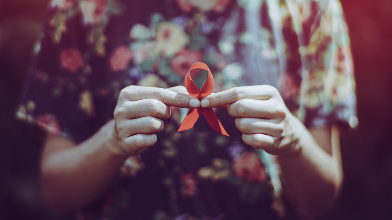 hands holding AIDS awareness ribbon
