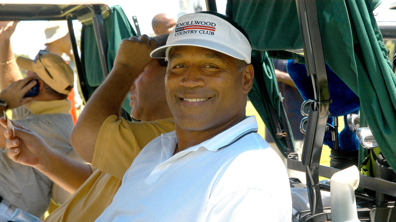 OJ Simpson on golf cart in hat