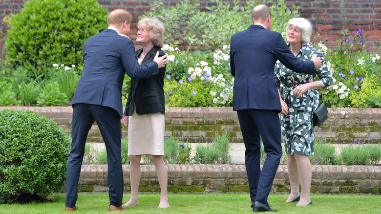 Princes William and Harry kissing their aunts in a garden