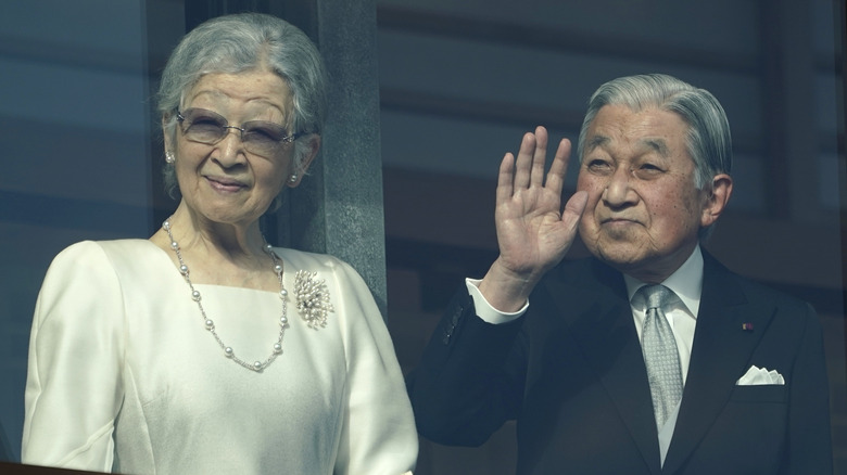 Emperor Akihito and Empress Shoda waving to crowd