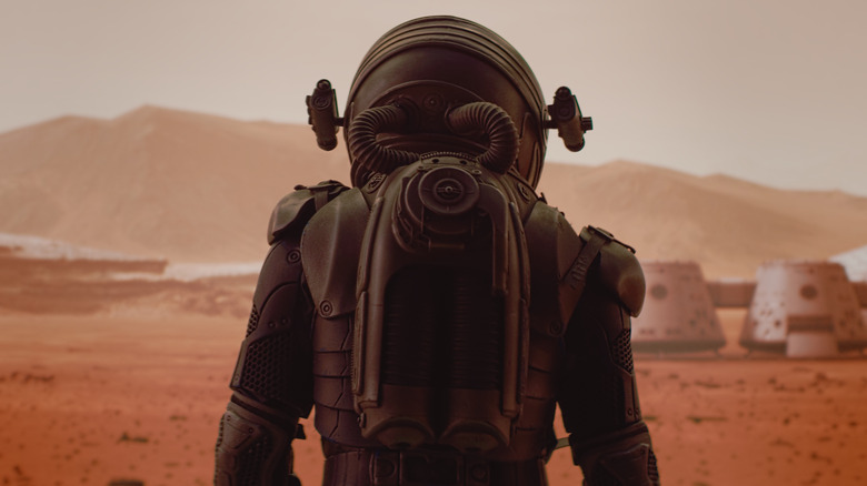 Astronaut looking out at martian colony