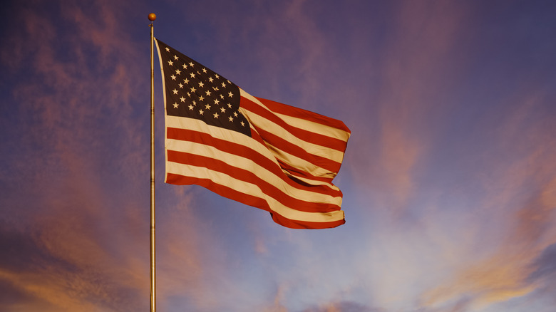 US flag waves at sunset
