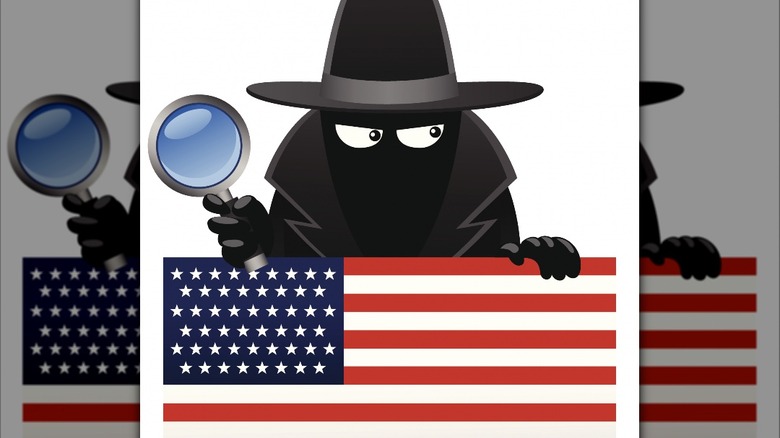 Spy with magnifying glass behind American flag
