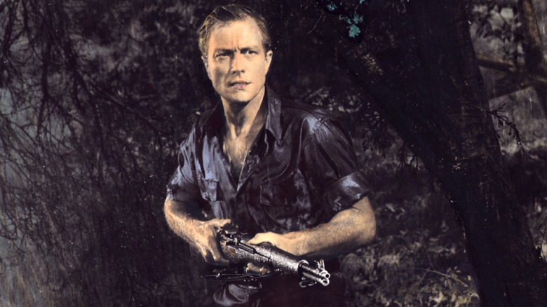 Richard Denning holds a rifle 