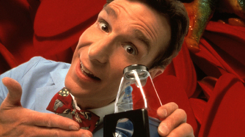 Bill Nye bowtie holding glass red background