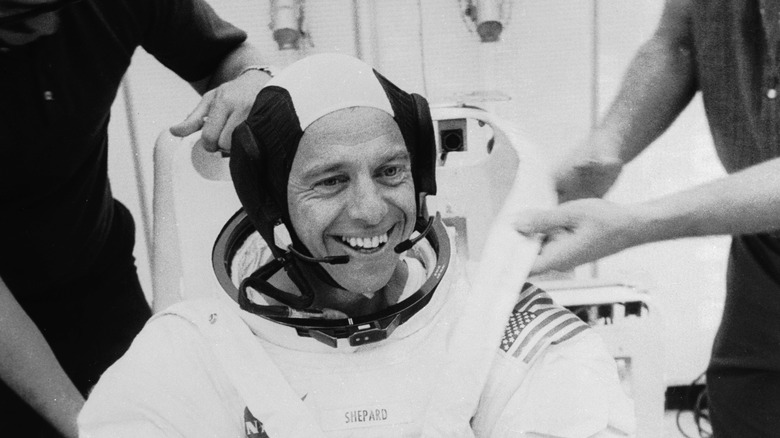 Alan Shepard smiling after landing on Earth in spacesuit