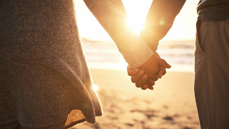 Couple on beach holding hands