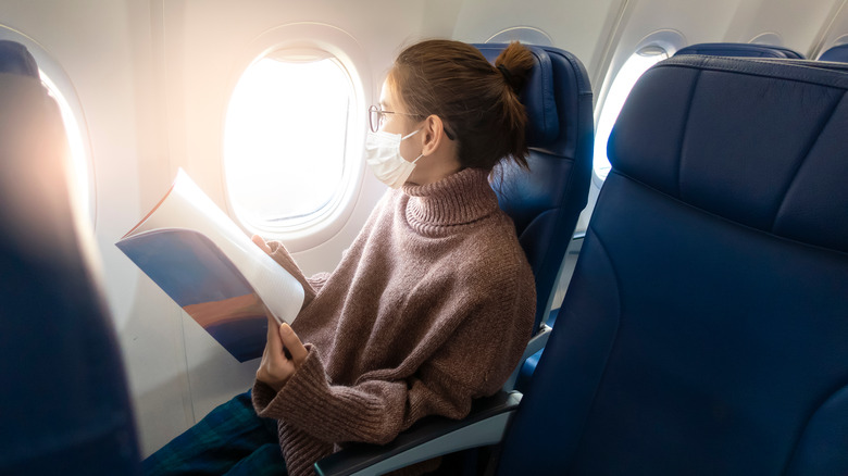 Woman in mask on plane