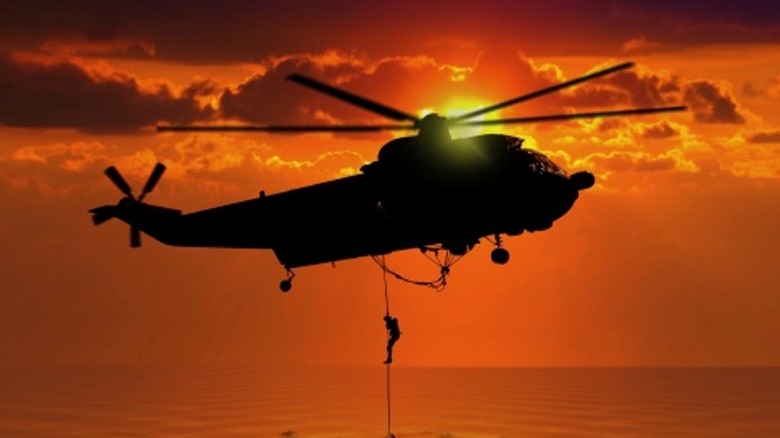 Rescue helicopter over the ocean sunset