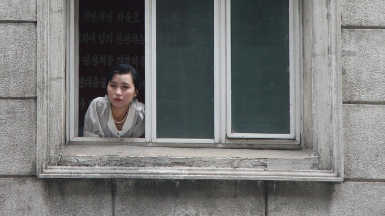 North Korean woman looking out a window