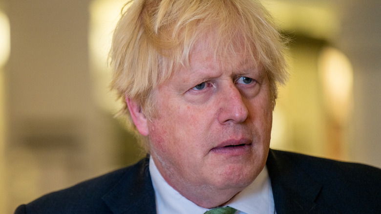 Boris Johnson frowning in green tie