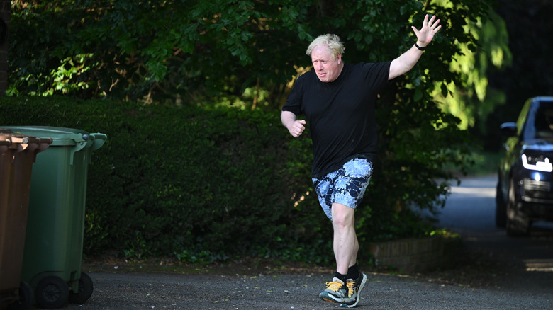 Boris Johnson jogging by a bin