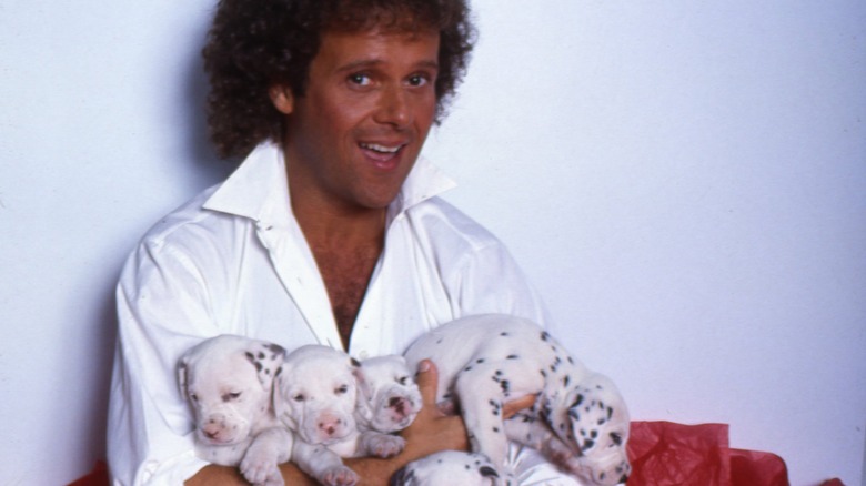 ricard simmons with an armful of puppies